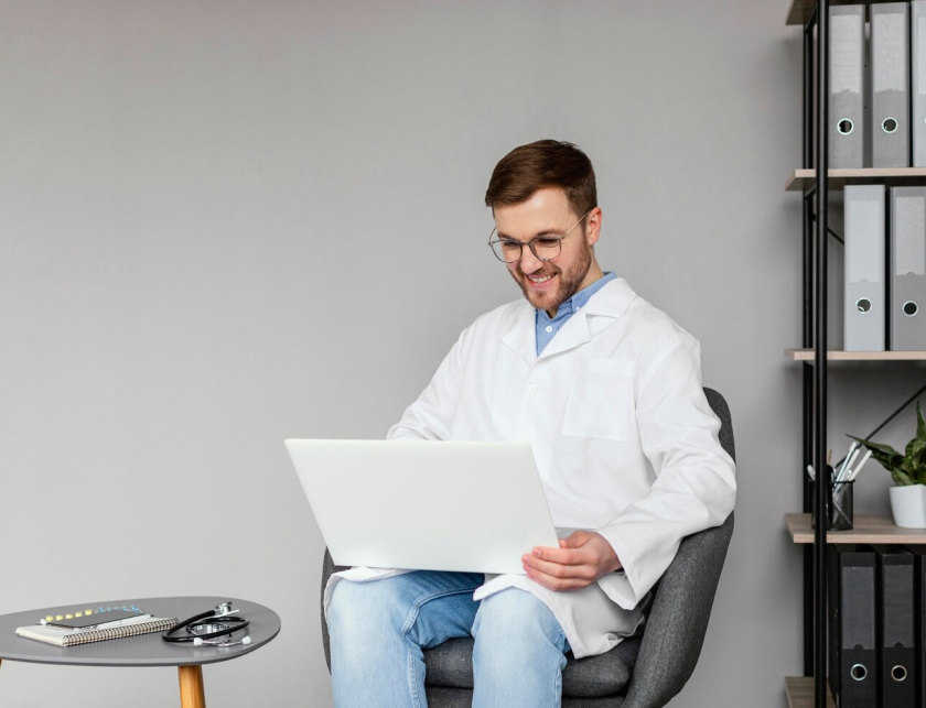 Smiling dentist working on a laptop